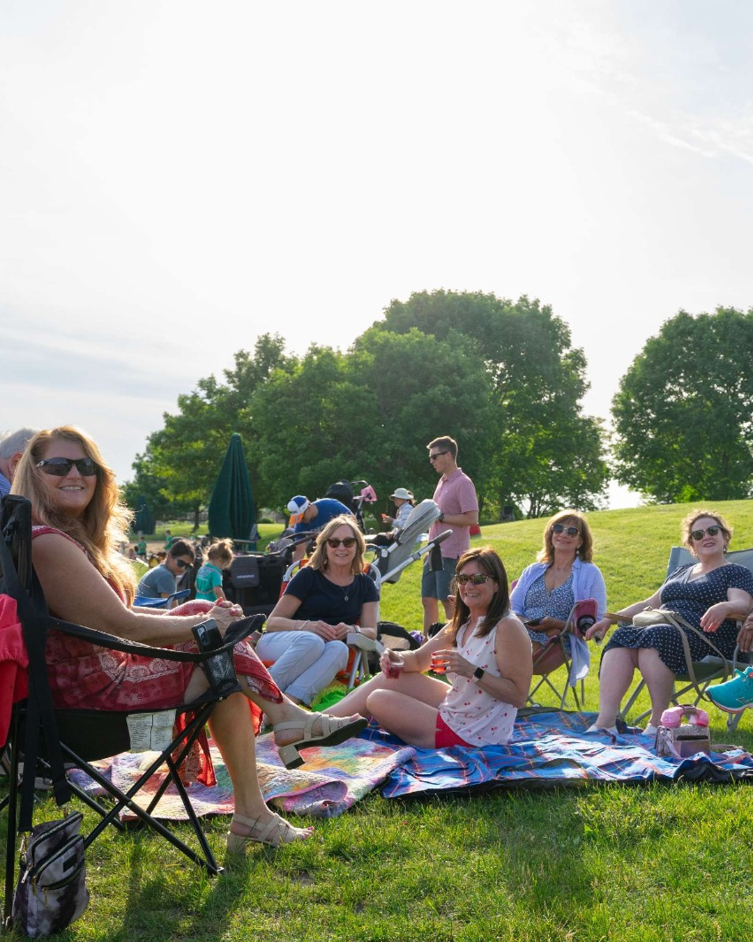 Crowd enjoying indpendence grove on a picnic blanket
