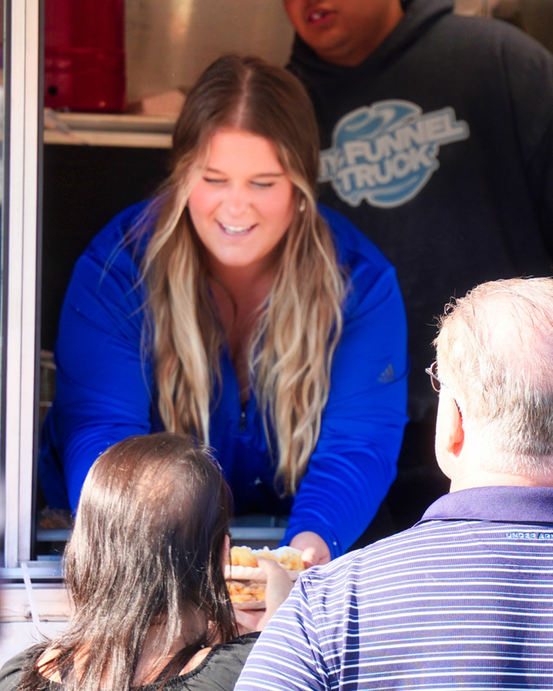 Woman handing out food to customers from a food truck at Lake County Fairgrounds
