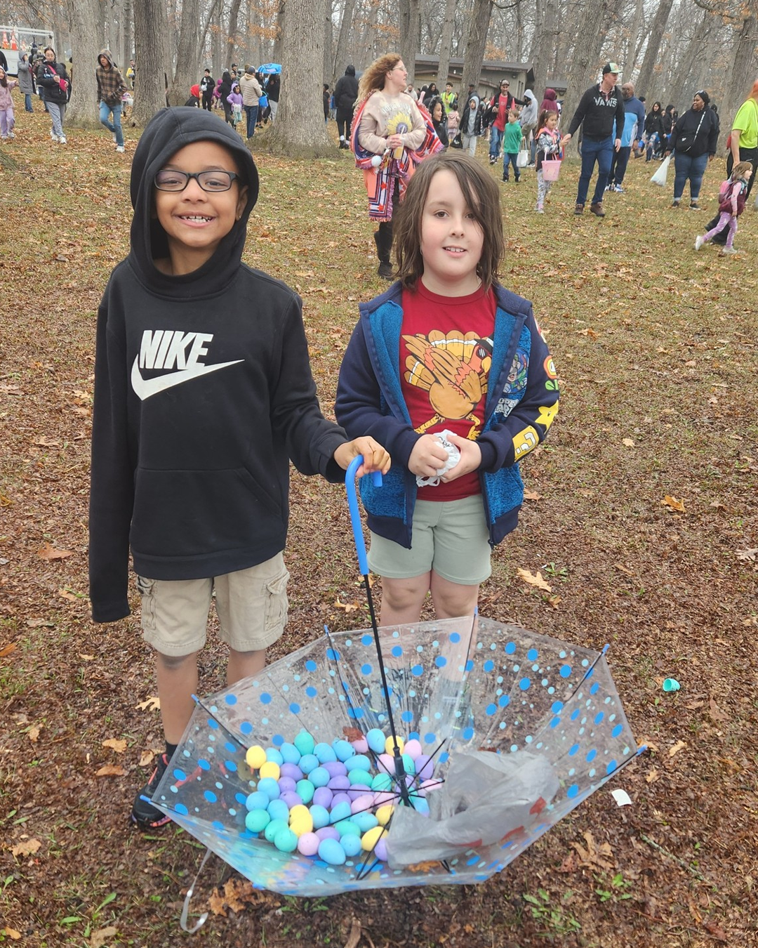 Two kids collecting Easter eggs with an umbrella at Zion Park District