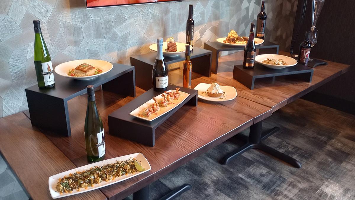A display table with the appetizer, entrée and dessert samples with their wine pairings